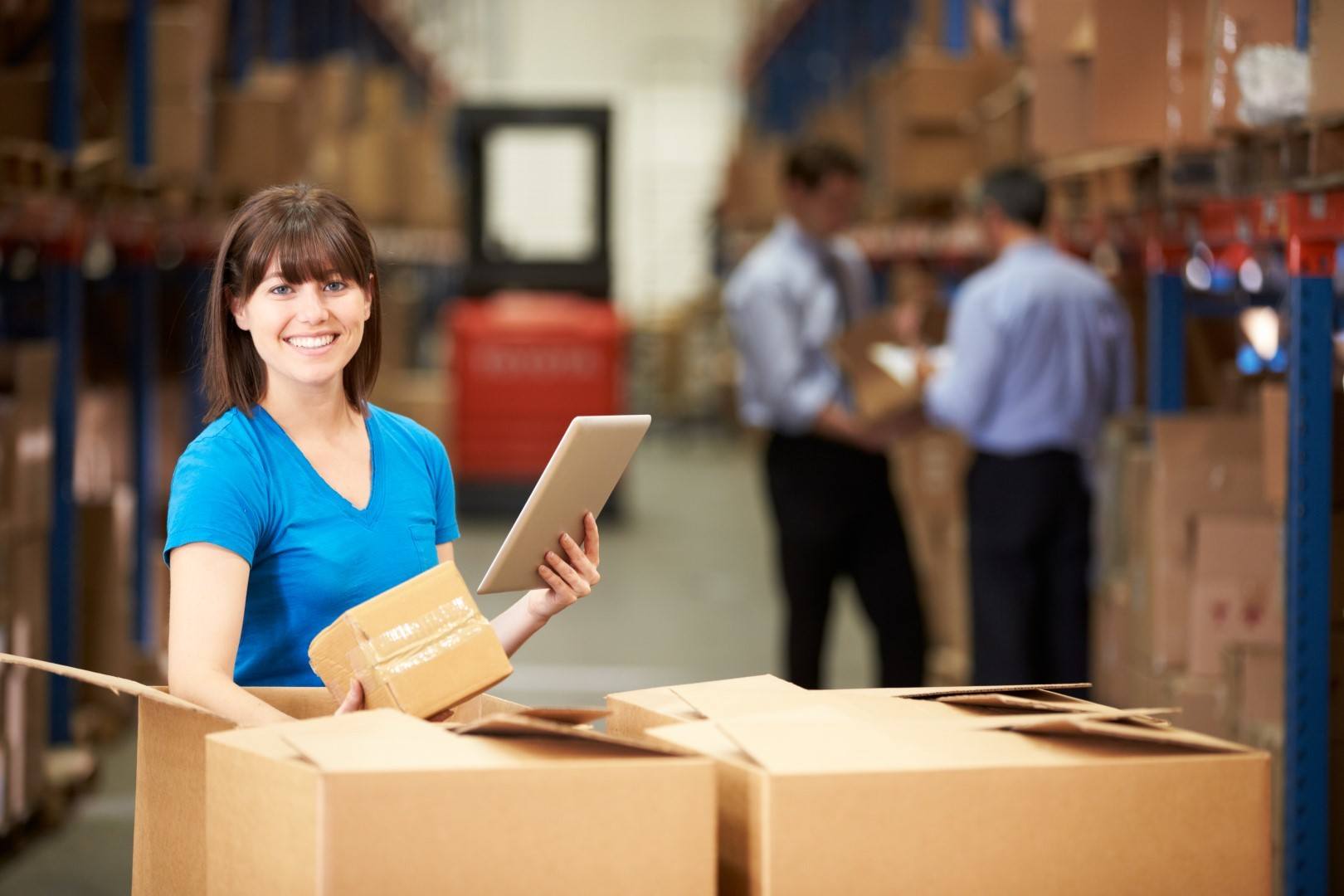 Worker In Warehouse Checking Boxes Using Digital Tablet